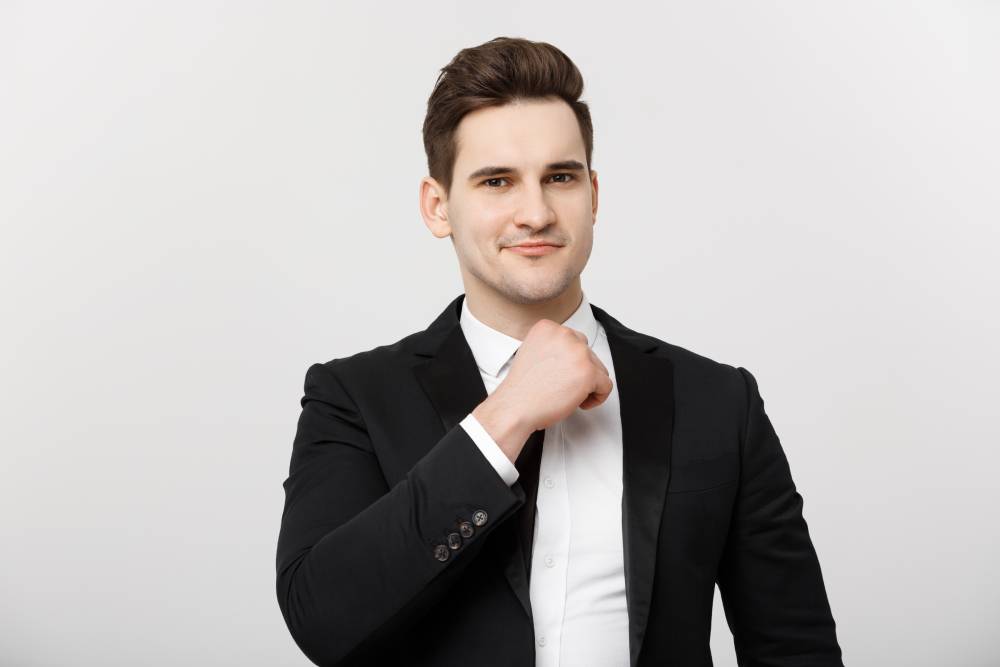 business-concept-smiling-thoughtful-handsome-man-standing-white-isolated-background-touching-his-chin-with-hand-1